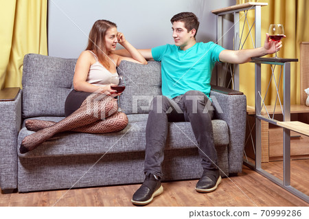 Young beautiful woman and man drink wine while have date. 70999286