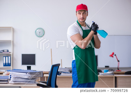 Young male contractor cleaning the office Young male contractor cleaning the office 70999726