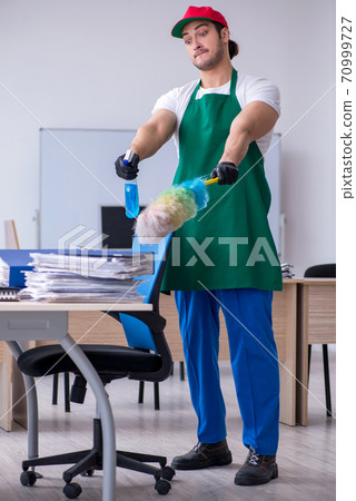 Young male contractor cleaning the office Young male contractor cleaning the office 70999727
