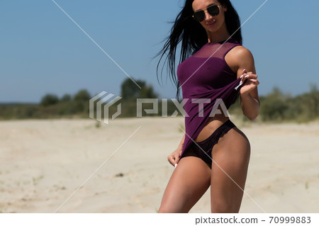 Beautiful woman in swimsuit on beach 70999883