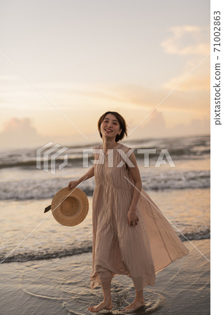 A woman walking along the beach 71002863