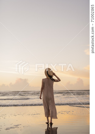 A woman walking along the beach 71002865