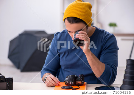Young male photographer working in the studio Young male photographer working in the studio 71004156