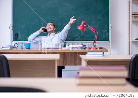 Young male teacher in front of green board Young male teacher in front of green board 71004192
