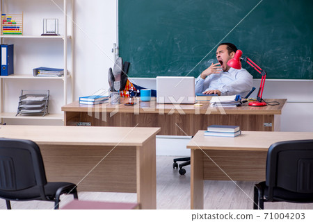 Young male teacher in front of green board Young male teacher in front of green board 71004203