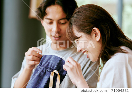 Men and women looking at the contents of the gift 71004281