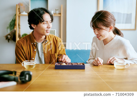 Women and men looking at chocolate Women and men looking at chocolate 71004309