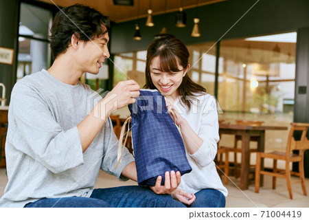 Men and women looking at the contents of the gift 71004419