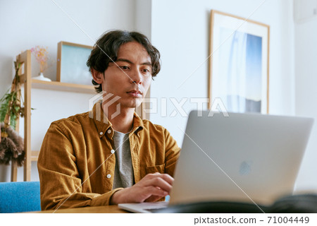 Men typing in the living room 71004449