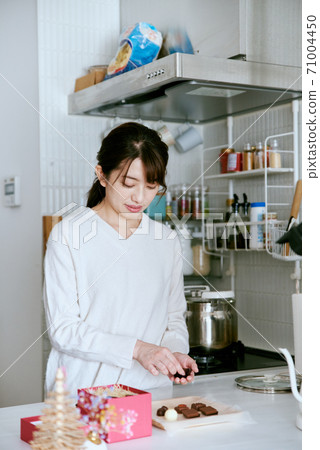 Woman cutting chocolate in the kitchen 71004450