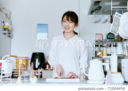 Woman cutting chocolate in the kitchen Woman cutting chocolate in the kitchen 71004456
