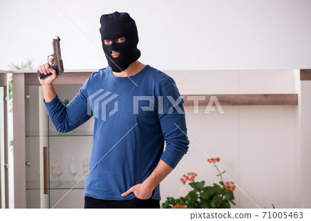 Male robber stealing valuable things from the house Male robber stealing valuable things from the house 71005463