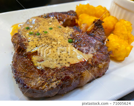 Beef steak with pepper sauce on top on the table Beef steak with pepper sauce on top on the table 71005624
