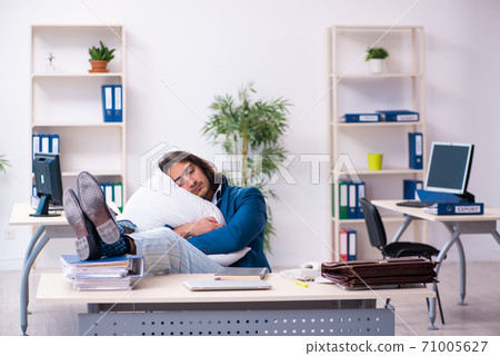 Male employee coming to work straight from bed Male employee coming to work straight from bed 71005627