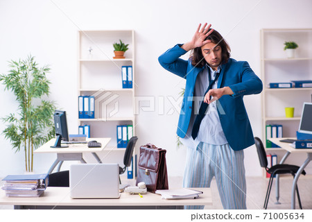 Male employee coming to work straight from bed Male employee coming to work straight from bed 71005634