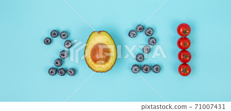 2021 Happy New Year and New You with fruits and Vegetables; Blueberries, Avocado and Totamo on blue background. Goals, Healthy, Resolution, Time to New Start and dieting concept 71007431