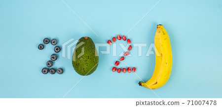 2021 Happy New Year and New You with fruits; Blueberries, Avocado, Pomegranate seeds and banana on blue background. Goals, Healthy, Resolution, Time to New Start and dieting concept 71007478
