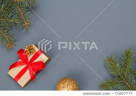 Gift box, fir tree branches and christmas ball on gray background Gift box, fir tree branches and christmas ball on gray background 71007777