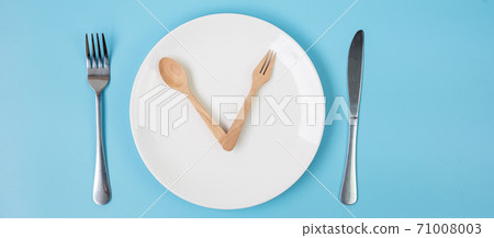 Top view white ceramic plate with knife, spoon and fork on blue background. Intermittent fasting, Ketogenic dieting, weight loss, meal plan and healthy food concept 71008003