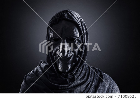 Portrait of a scary witch in hooded cloak Portrait of a scary witch in hooded cloak 71009523
