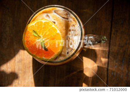 espresso shot mixed with soda on bottom in transperant glasses mug with coffee bubble topping by orange mint on wooden table in morning light refreshment stock photo 71012000