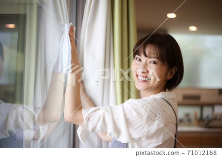 Woman cleaning the window 71012168