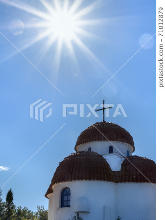 Big bright sun at church on hills of Nea Roda village 71012879