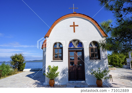 Orange and white church on hills of Nea Roda village and port 71012889