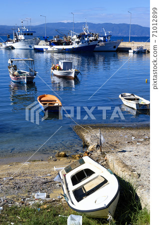 Boats in the port of Nea Roda on blue sea water 71012899