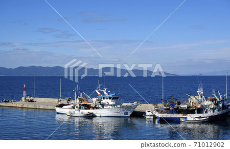 Boats in the port of Nea Roda on blue sea water 71012902