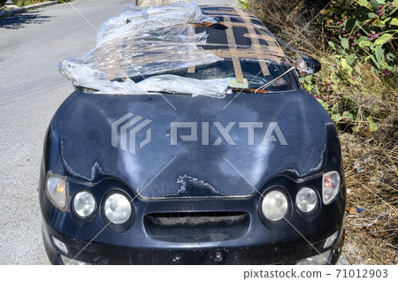Old dark blue ruined abandoned car in the street Old dark blue ruined abandoned car in the street 71012903