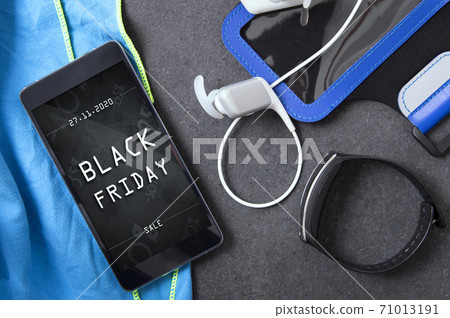 Smartphone with black friday banner lying on the stone slab with sport accessory Smartphone with black friday banner lying on the stone slab with sport accessory 71013191