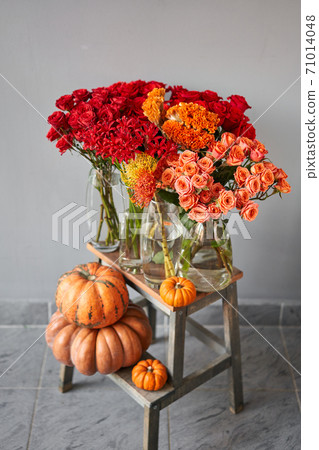 Set of pumpkins and orange and red flowers for Interior decorations. The work of the florist at a flower shop. Fresh cut flower. Autumn mood. 71014048