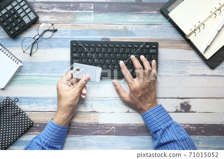 man hands holding credit card and using keyboard shopping online man hands holding credit card and using keyboard shopping online 71015052