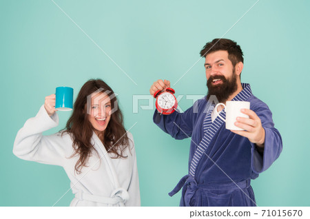 Every morning begins with coffee. Couple in bathrobes with mugs. Man 71015670
