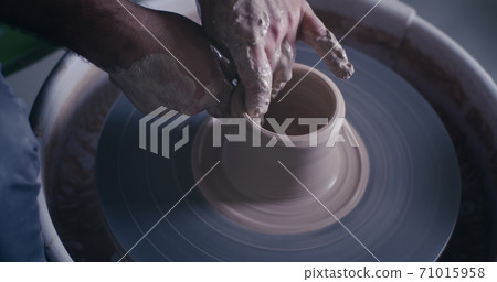 Crop ceramist creating pot on spinning wheel Crop ceramist creating pot on spinning wheel 71015958