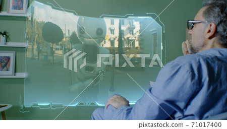 Senior male choosing movie on futuristic TV Senior male choosing movie on futuristic TV 71017400