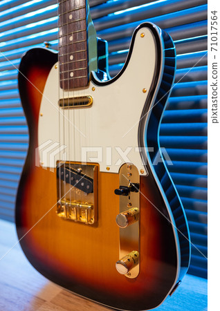 Sunburst electric guitar telecaster shape (gold hardware) on woden table in the room. businoess and music concept. Wallpaper or background Sunburst electric guitar telecaster shape (gold hardware) on woden table in the room. businoess and music concept. Wallpaper or background 71017564