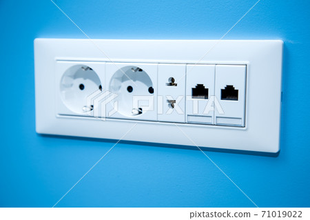 Socket electrical outlets for electrical plugs and electricity a set of different types of power connectors for European and American stanlart and connect the Internet cable close-up on the blue wall. 71019022