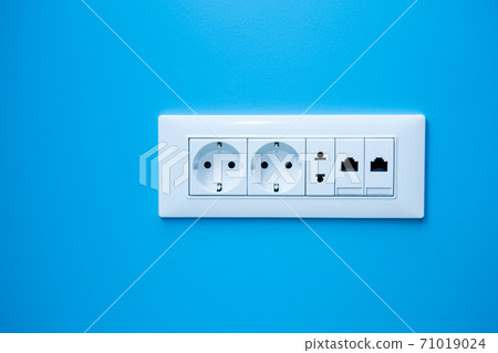 a socket on a light blue wall, a multiple outlet with an internet connection, two European type and one American type outlet. a socket on a light blue wall, a multiple outlet with an internet connection, two European type and one American type outlet. 71019024
