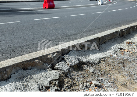 Road works are a freshly installed curb and poured with concrete along the route with new asphalt. Road works are a freshly installed curb and poured with concrete along the route with new asphalt. 71019567