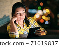 Young Woman Holding Ereader And Reading Ebook At Night 71019837