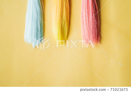 Colorful dolls hair on pink background 71021673