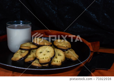Halloween skull cookies with milk and butcher knife Halloween skull cookies with milk and butcher knife 71022016