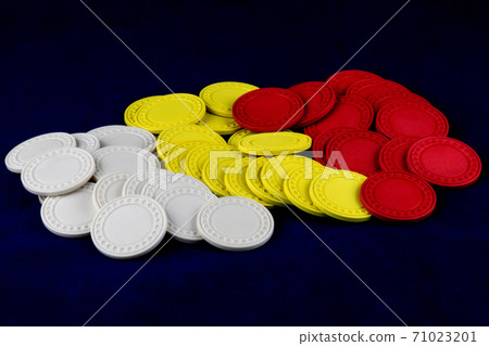 Pile of Coloured Gaming Chips on a Blue Background Pile of Coloured Gaming Chips on a Blue Background 71023201