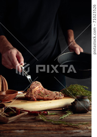 Chef prepare steak. Uncooked steak in sauce with spices an rosemary. 71023526