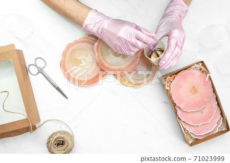 Creativity and craft. A young girl creates coasters from resin. Gift wrapping. Decorative packaging. Idea for business. Remote work, work at home. Art coasters. 71023999