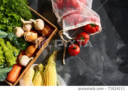 Fresh fruits and vegetables in reusable shopping bags. 71024211