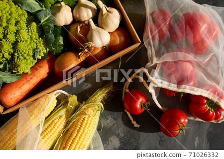 Fresh fruits and vegetables in reusable shopping bags. 71026332
