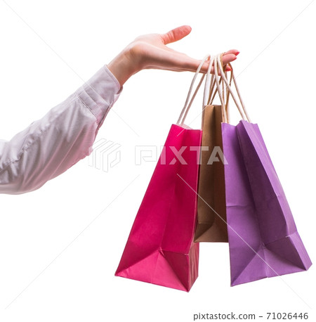 Hand holding shopping bags with christmas shopping on white back Hand holding shopping bags with christmas shopping on white back 71026446